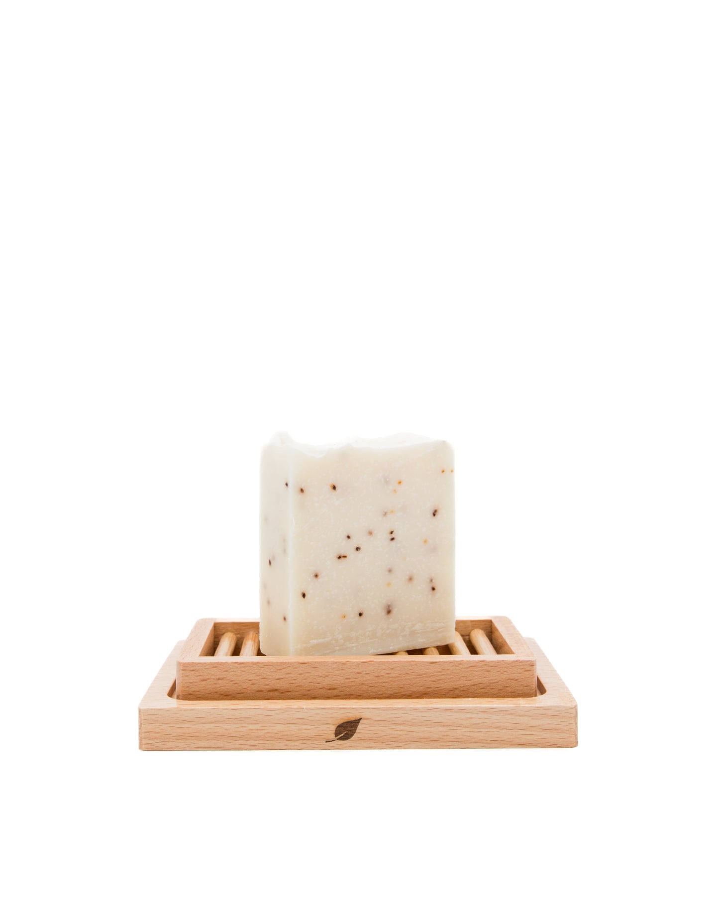Bar of soap on a wooden soap dish against a white background